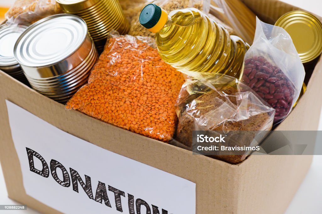 Food in donation cardboard box, isolated on white background Food in a donation cardboard box, isolated on white background Charitable Donation Stock Photo