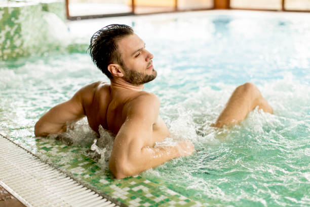istock Handsome young man relaxing in hot tub 928890568