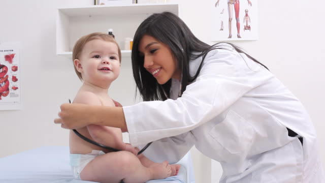 Pediatrician checking baby’s heart beat with stethoscope