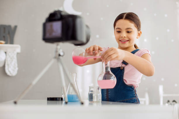 istock Upbeat girl mixing chemicals on camera 928891776