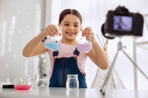 istock Upbeat girl showing two chemical flasks on camera 928891800