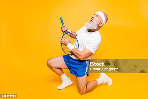 Sexy Emotional Cool Pensioner Grandpa Practising Rock Music On A Sport Equipment Stands On One Knee Yell And Shout Body Care Hobby Weight Loss Lifestyle Strength And Power Health Stock Photo - Download Image Now