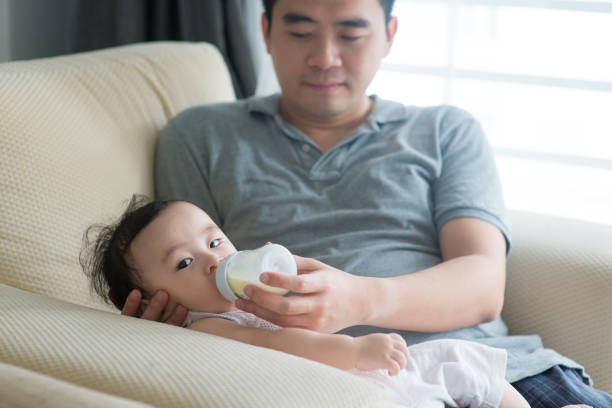istock Father bottle feed milk to baby. 928898544