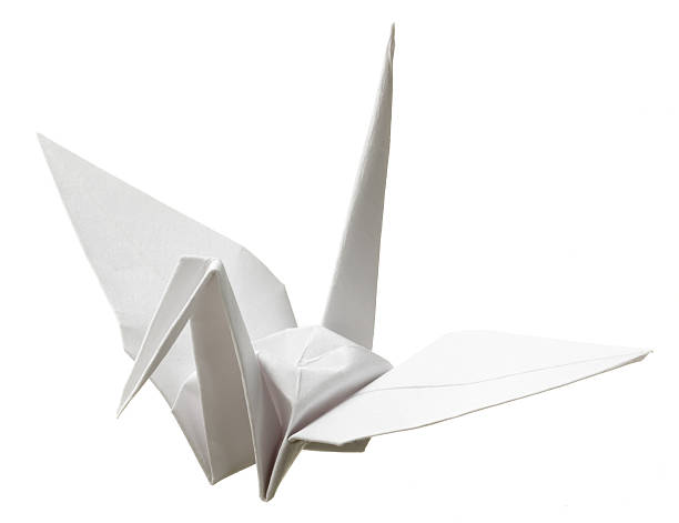 Origami white paper bird on white background A paper origami crane. origami cranes stock pictures, royalty-free photos & images