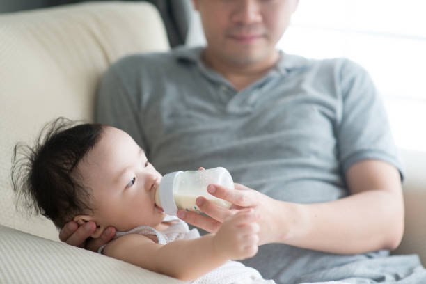 istock Father bottle feed milk to child. 928901696