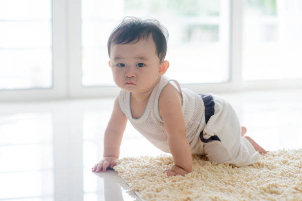istock Healthy baby boy crawling on carpet. 928902030