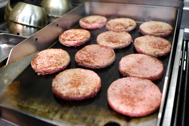 istock Rows of burger patties cooking on a hot griddle 928902664