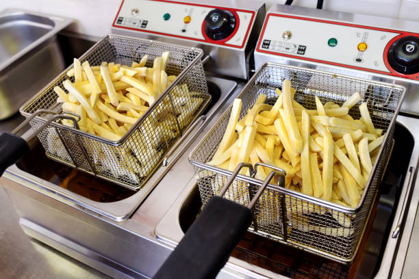 istock Crispy golden potato chips draining on a fryer 928905408