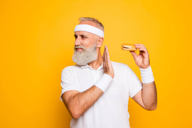 istock No way! Enough! Serious strict harsh cool athlete holds sandwich, warning with arm, challenge, figure, ban, veto, hunger, interdiction, restrain, refusal, junk food, cheat meal, denial, motivation 928906084