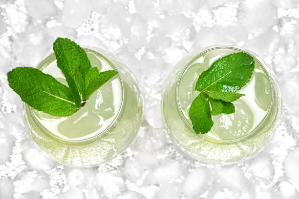 Refreshing drink with mint in large wine glasses surrounded by ice cubes. Close-up, top view. Cold mojito. Ice lemonade