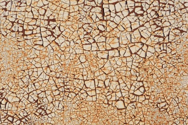 Rugged texture of finely cracked paint on rusty surface background closeup
