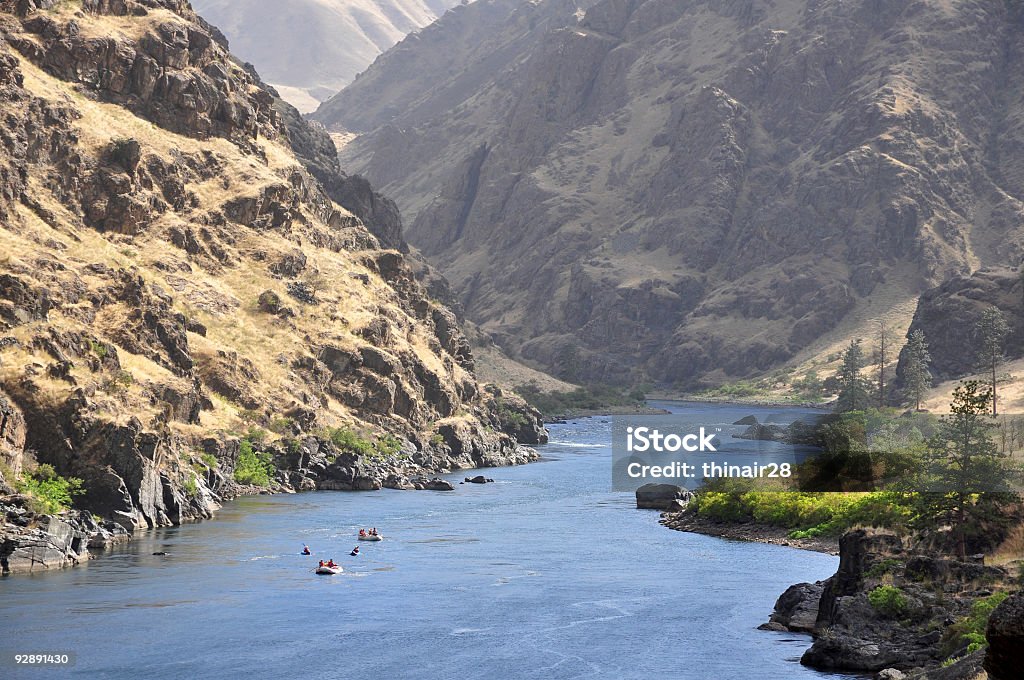 People rafting along Hells Canyon Rafts and kayaks descend the Snake River in Hells Canyon on the border between Idaho and Oregon. White Water Rafting Stock Photo