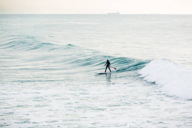 istock Surfer on sup board on ocean waves. Stand up paddle boarding in ocean 928916858