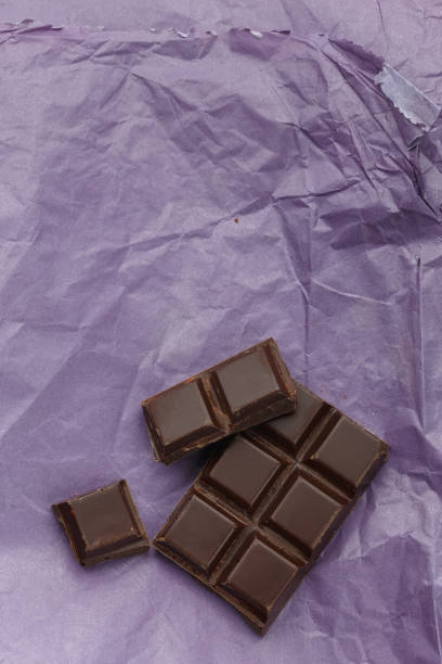 istock Dark chocolate bar on purple crumpled paper 928916924