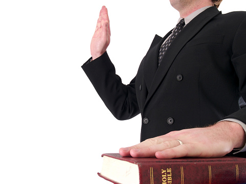 a man being sworn in to testimony isolated on white.