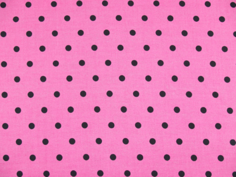 pink with black polka dots fabric background pattern.
