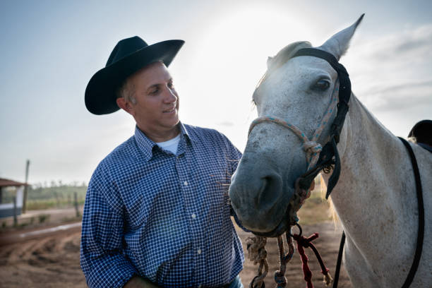 istock Happy man working at a farm with a horse 928917672
