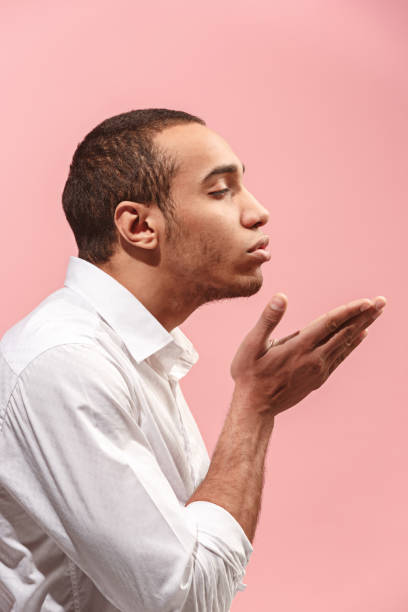 retrato de hombre atractivo con beso aislado sobre fondo rosa - blowing men kissing blowing a kiss fotografías e imágenes de stock