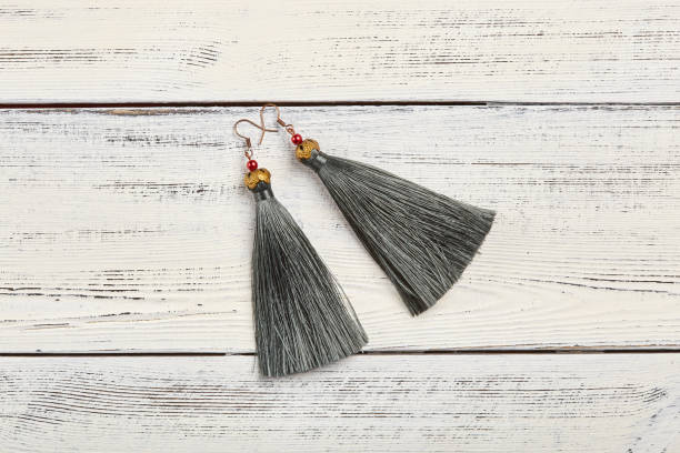 istock Gray tassel earrings on white background 928925904