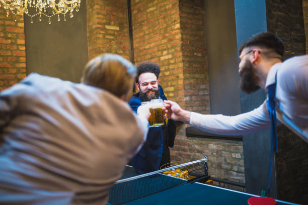 istock Group of young businessman taking break, playing table tennis at modern creative space 928929464