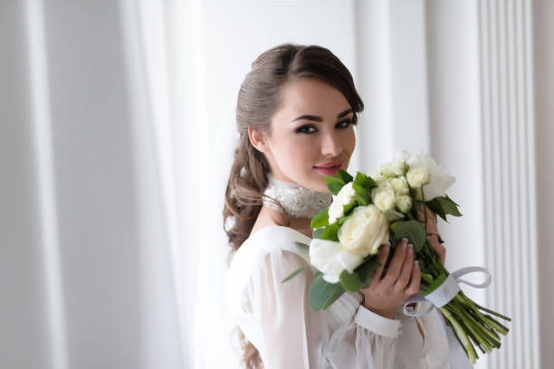 istock elegant smiling bride with wedding bouquet 928929502