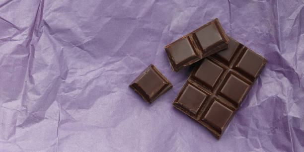istock Dark chocolate bar on purple crumpled paper 928932330