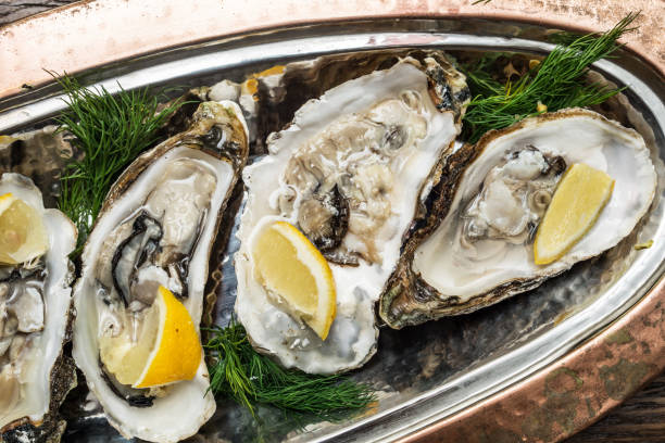 istock Opened oysters with piece of lemon. 928933046
