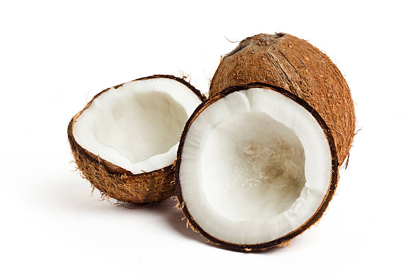 Coconut cracked open with a whole coconut on white back Coconut on white background coconut stock pictures, royalty-free photos & images