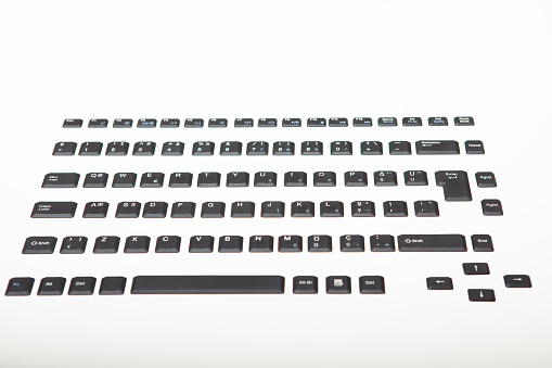 High angle view of a Qwerty alphanumeric computer keyboard with black keys on silver gradient to white with copy space above