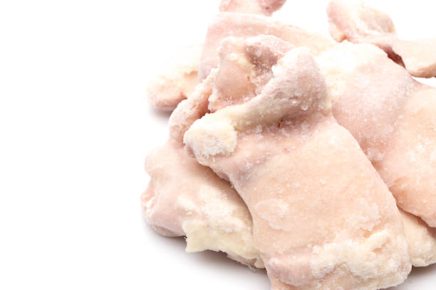 istock Raw Frozen Chicken Thighs on a White Background 928954982
