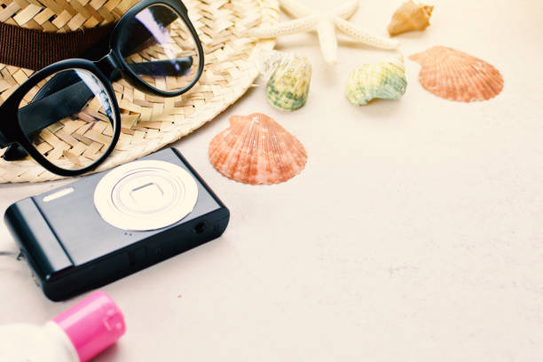 istock Close-Up Of Seashells And Camera By Straw Hat On White Background 928957556