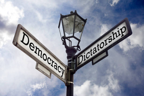 Democracy Vs. Dictatorship Street sign illustrating the concept of Democracy versus Dictatorship. exploitation stock pictures, royalty-free photos & images