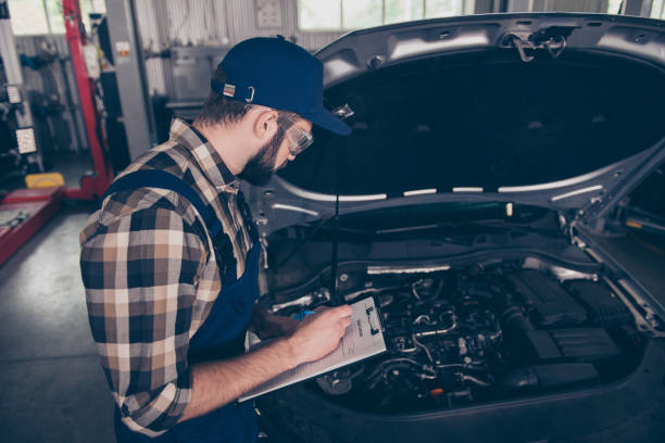 istock Above top view of focused, serious, concentrated expert professional engineer at mechanical work shop, in special safety outfit uniform, checkered shirt, hat head wear, filling the form of breakdown 928962076