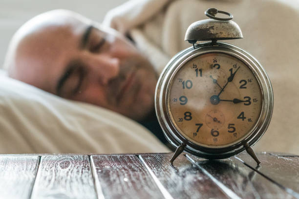 istock Sleeping man lying in bed and alarm clock 928969034