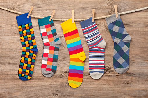 Multi colored socks on wooden background. This file is cleaned and retouched.