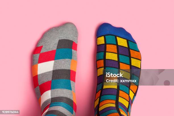 Foot In Different Colorful Socks On Pink Background Stock Photo - Download Image Now