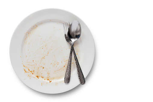 Top view of empty plate, dirty after the meal is finished isolate with clipping path and copy space for text on right area, sauce smeared on a plate.