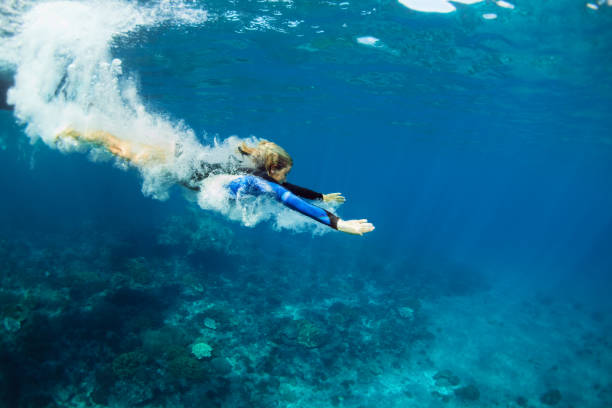 Young woman diving underwater Happy family - active teenage girl jump and dive underwater in tropical coral reef pool. Travel lifestyle, water sport, snorkeling adventure. Swimming lessons on summer sea beach vacation with kids raro stock pictures, royalty-free photos & images