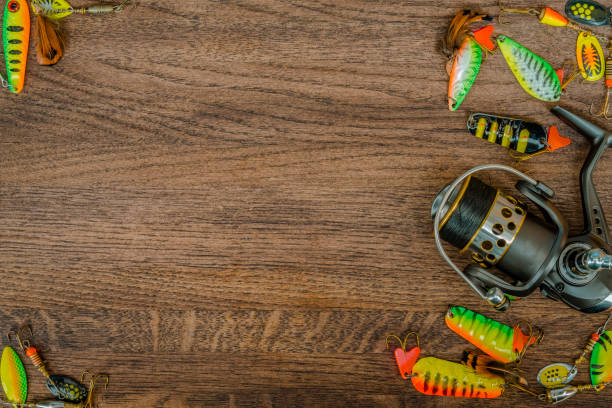 istock Fishing tackle on wooden background. Spoon bait. 928996016