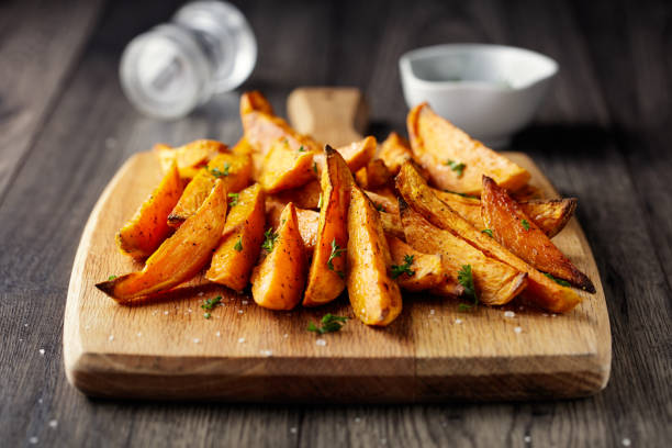 roasted Sweet potatoes wedges Home made freshness roasted sweet potatoes wedges with garlic herbs sweet potato photos stock pictures, royalty-free photos & images