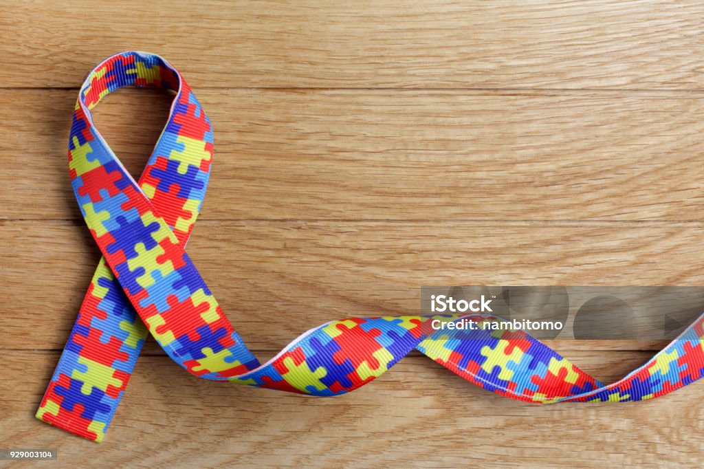 World Autism awareness and pride day or month with Puzzle pattern ribbon on wooden background. World Autism awareness and pride day with Puzzle pattern ribbon on wooden background Autism Stock Photo