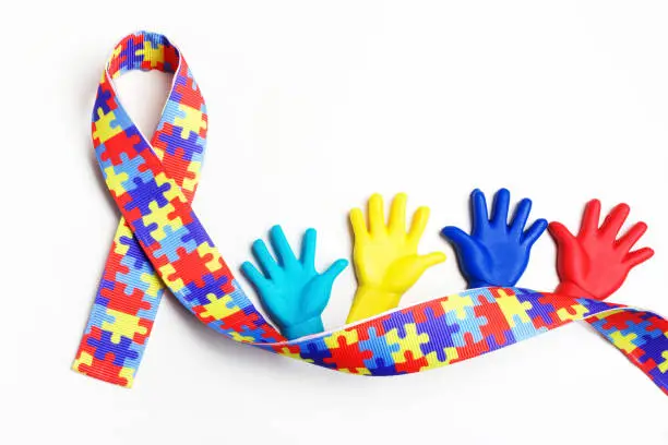 Photo of Autism awareness concept with colorful hands on white background. Top view