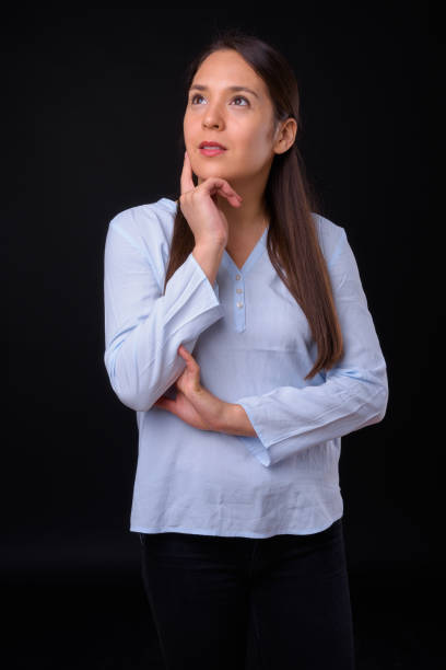 istock Young beautiful multi-ethnic businesswoman against black background 929003610