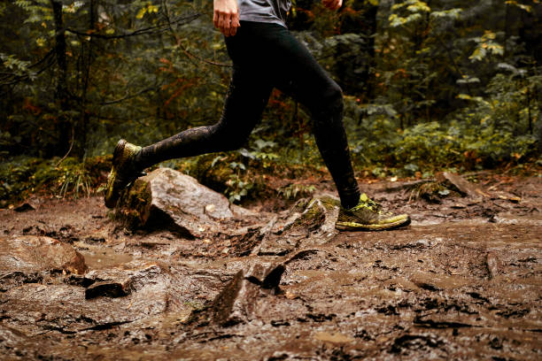 istock feet men runner running spring trail of mud and water 929004320