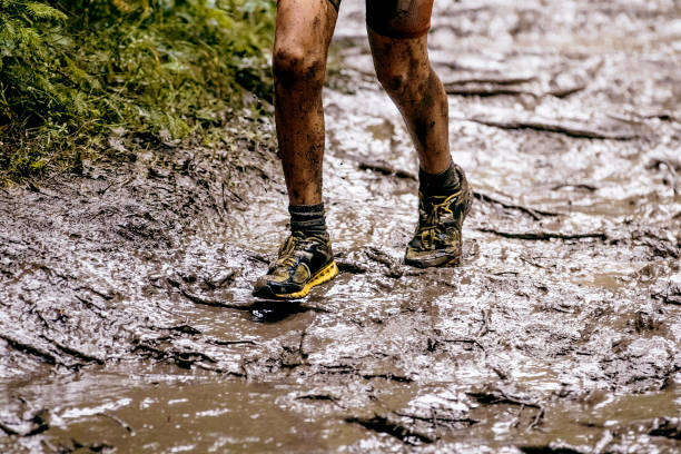 istock spring trail running in mud and water feet runner men 929005152