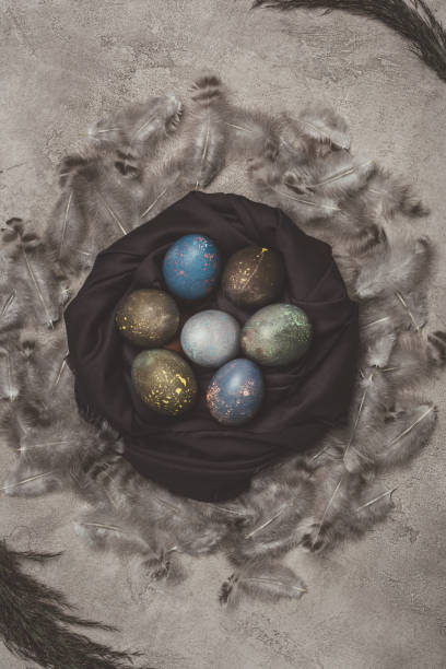 istock top view of easter eggs in nest with feathers on concrete surface 929008142