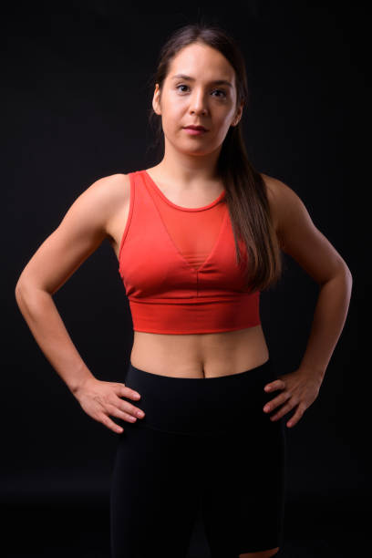istock Young beautiful multi-ethnic woman ready for gym against black background 929008274