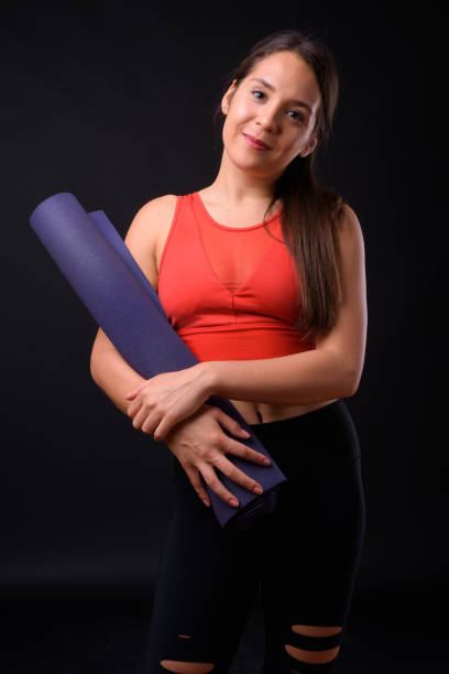 istock Young beautiful multi-ethnic woman ready for gym against black background 929008340