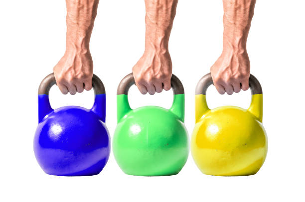 istock Strong muscular man hand with muscles holding several heavy kettlebells partially isolated on white background 929012452