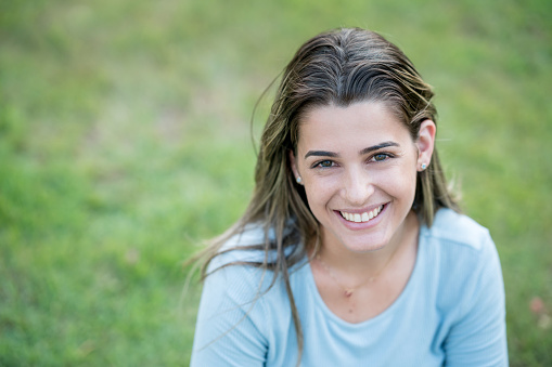 Portrait of a beautiful woman outdoors and looking at the camera smiling - lifestyle concepts